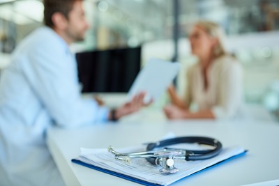 Doctor's office clerk explaining insurance benefits to customer, patient