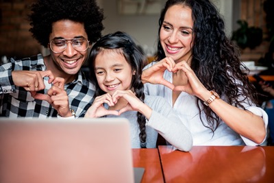 Happy multiethnic family having fun while using laptop together, video chat concept