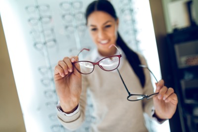 Woman selecting eyeglasses in optical store